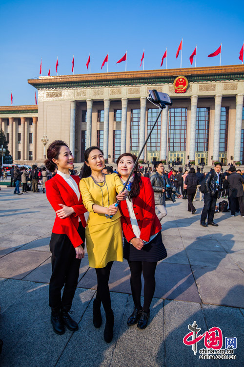 2015年3月5日，第十二屆全國人大第三次會議開幕會，三位女記者在人民大會堂前合影留念。中國網 鄭亮 攝