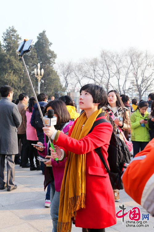 2015年兩會，來自山東的一位紅衣美女記者在人民大會堂前自拍留念。中國網 董寧 攝